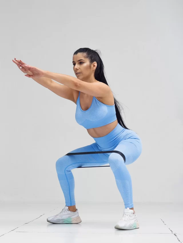 sports-woman-fashion-clothes-squatting-with-fitness-resistance-band
