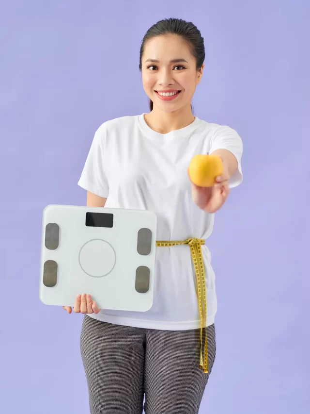 fit-fitness-woman-with-measure-tape-holding-weight-scale-one-orange-another-hand