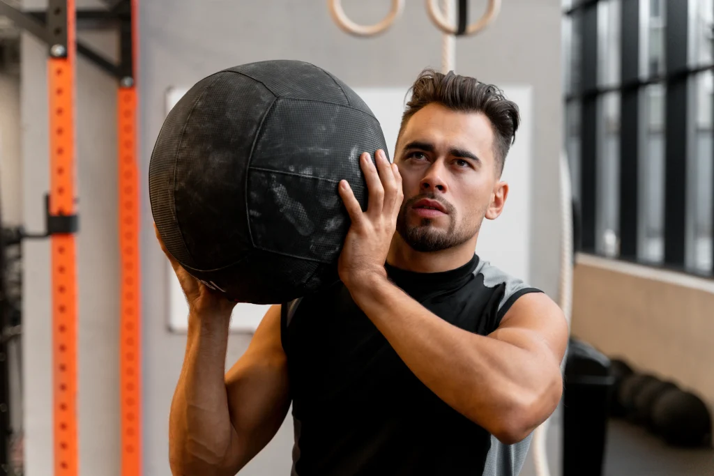 attractive fit man working out indoors with exercise ball 1